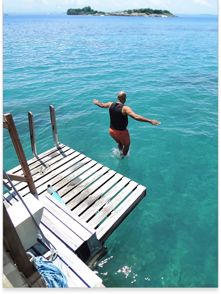 A woman jumping off of a dock into the ocean.