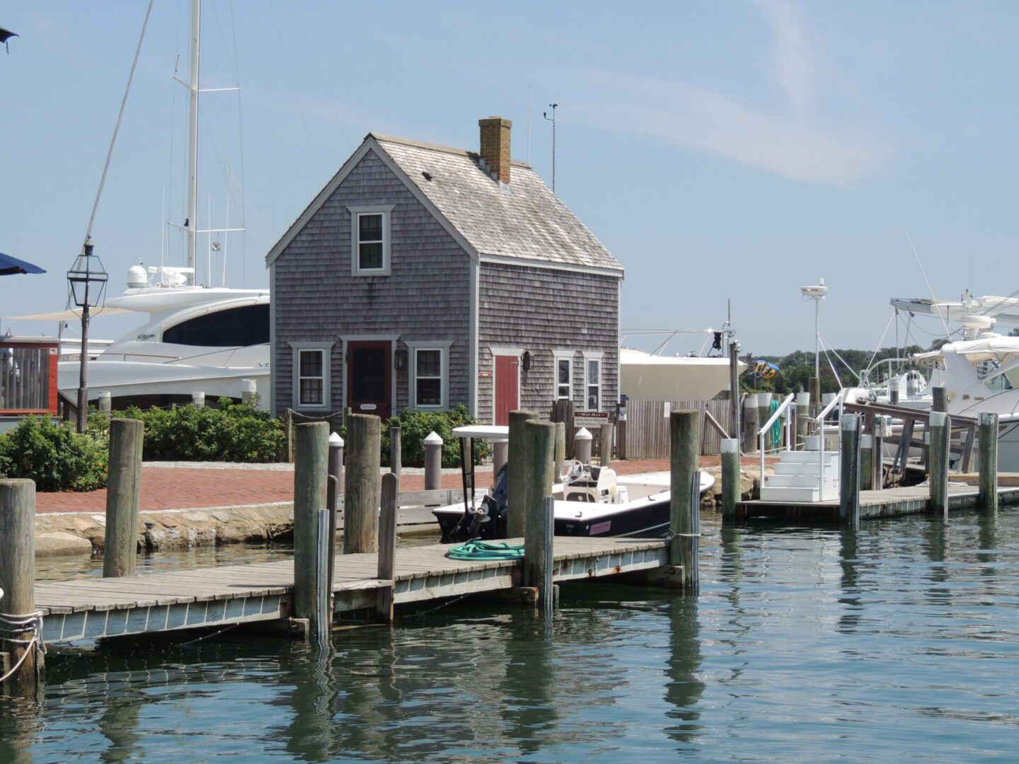 A boat dock with a house and boats in the background.